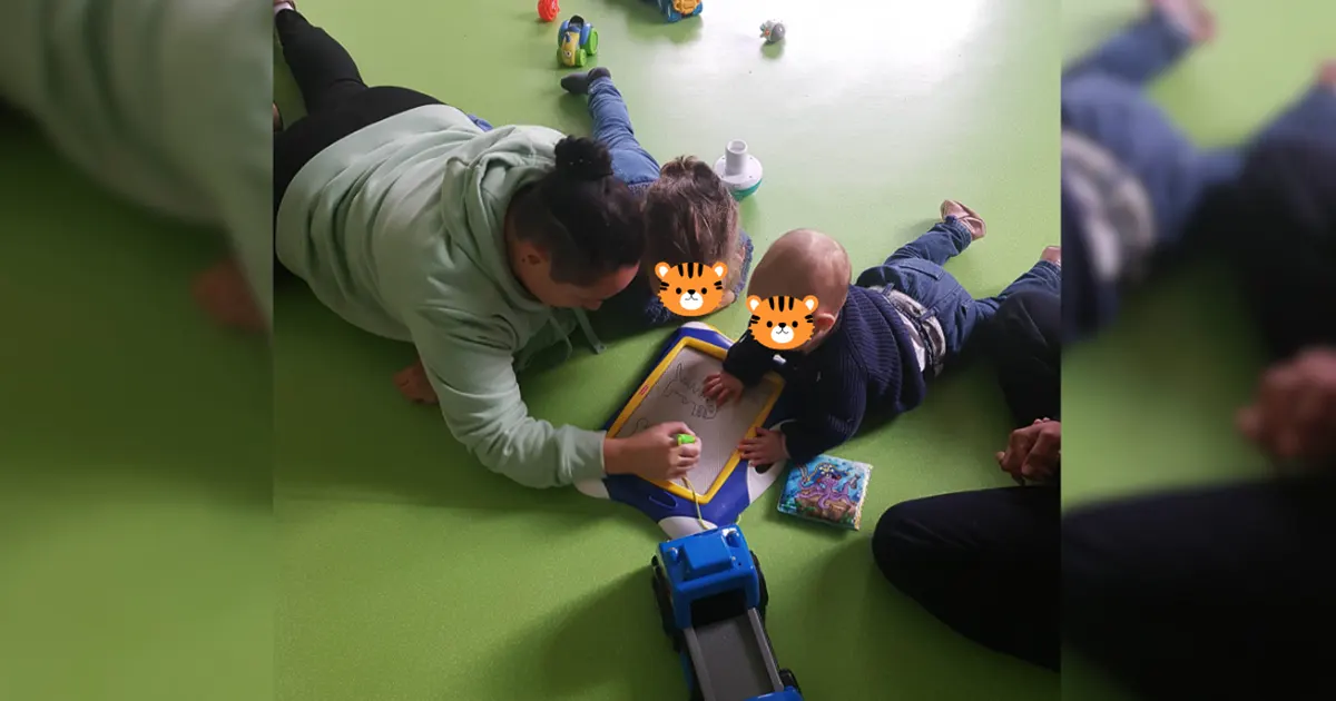 Deux enfants en activité créative accompagnés de près par un professionnel en micro-crèche à Sélestat