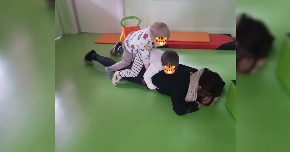 Deux bébés assis sur une professionnelle jouant avec eux en micro-crèche à Sélestat